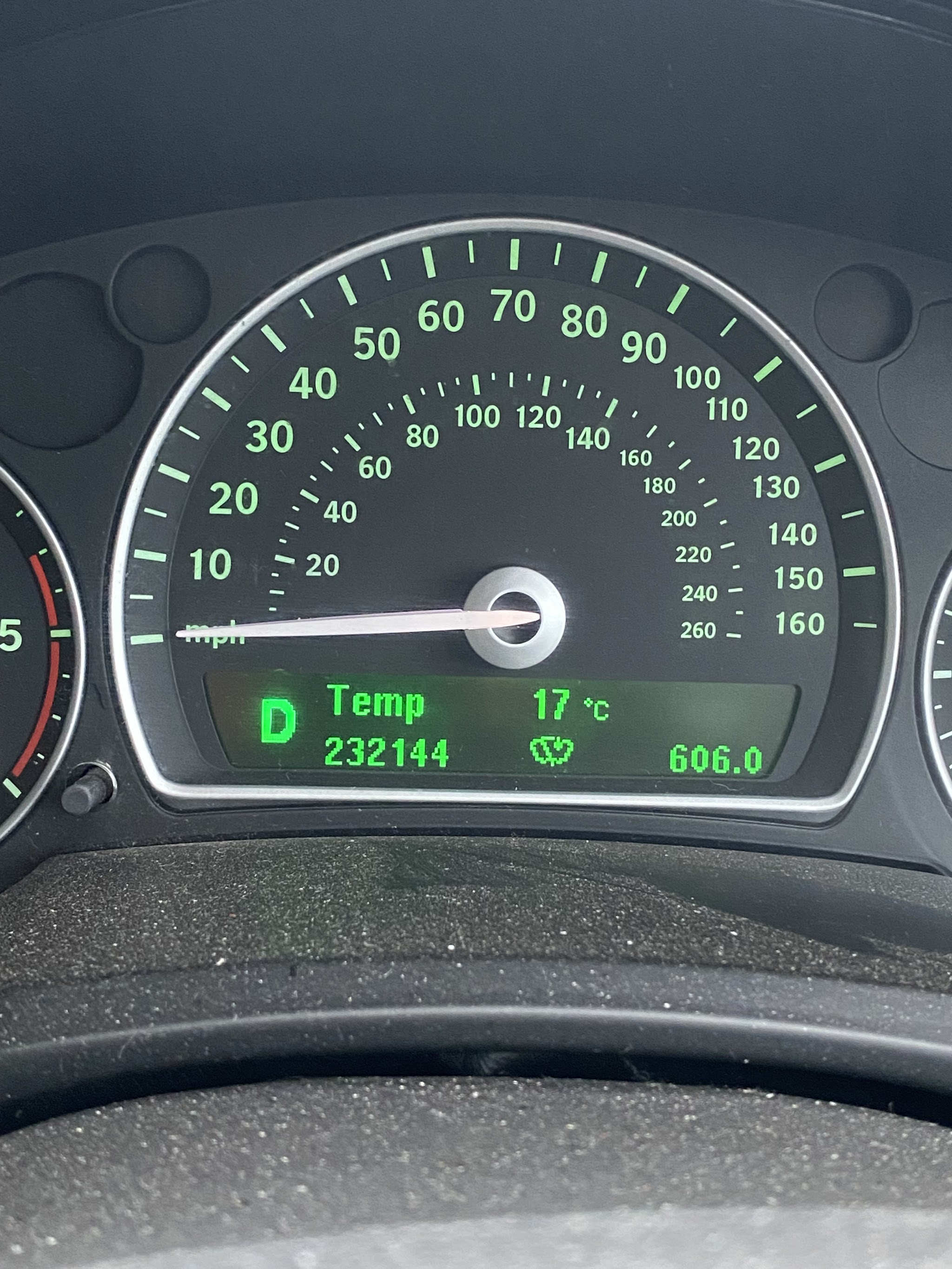 A SAAB 9-3 instrument cluster lit in green, reading 232144 miles
